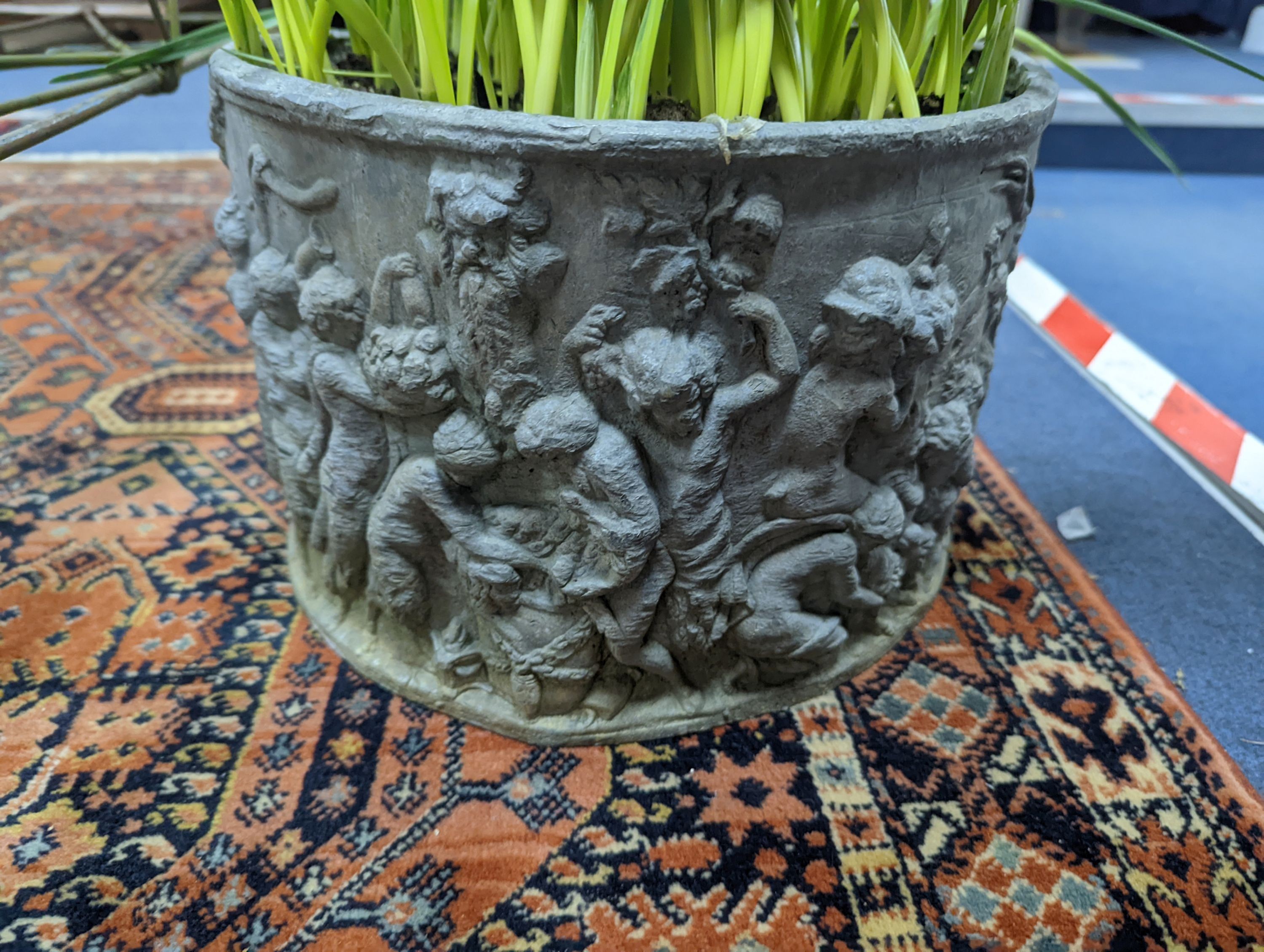 A circular lead planter moulded with Bacchic putti, diameter 30cm